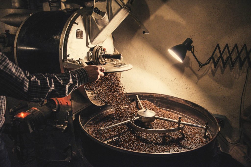 Coffee roasting drum with freshly roasted beans tumbling out